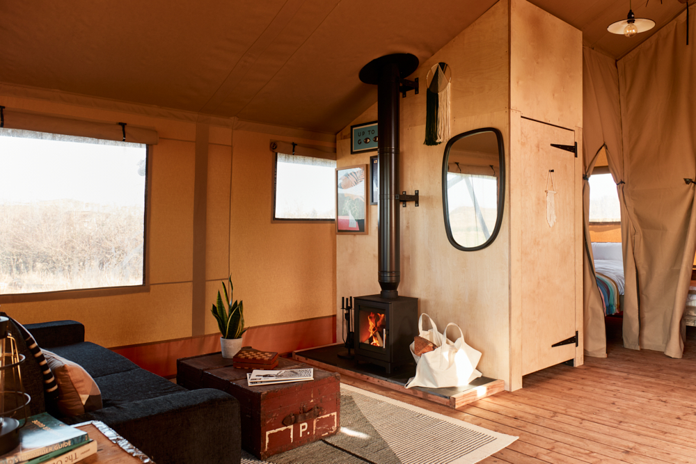 
								Living area, toilet and two bedrooms in the glamping safari tent at The Camp at The Wave great campsite for UK holidays							