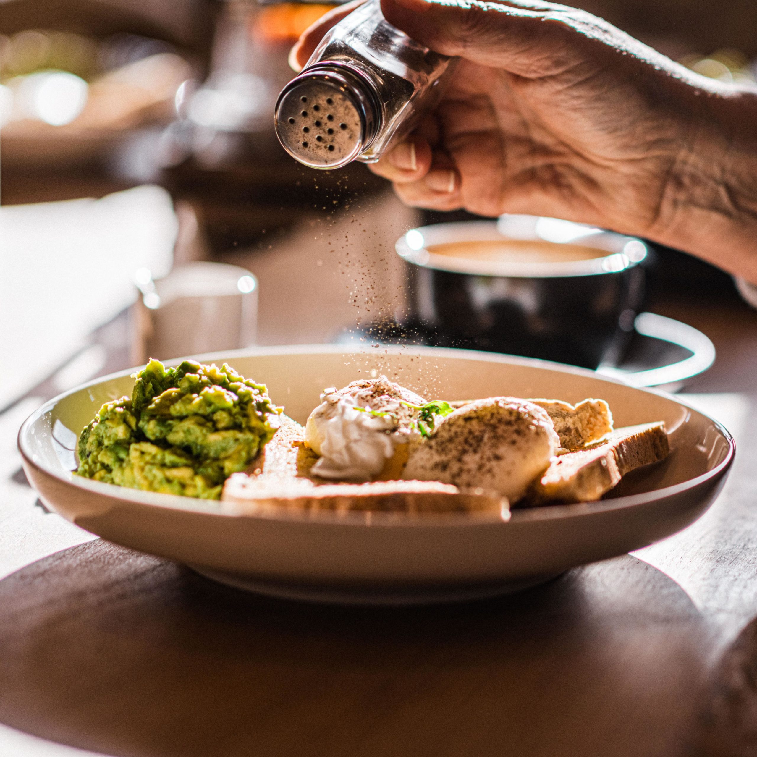 
								A man eats brunch of eggs, toast and avacado in the clubhouse cafe bar at The Wave inland surf lake							